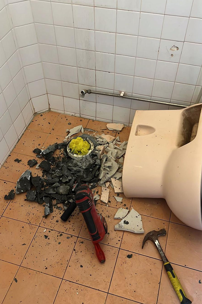 Plumber repairing a leaking toilet bowl in a Singapore HDB bathroom